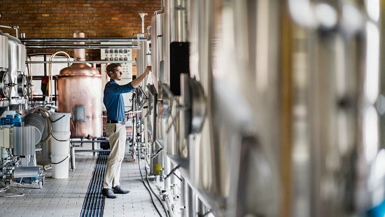 brewer checking fermentation tanks